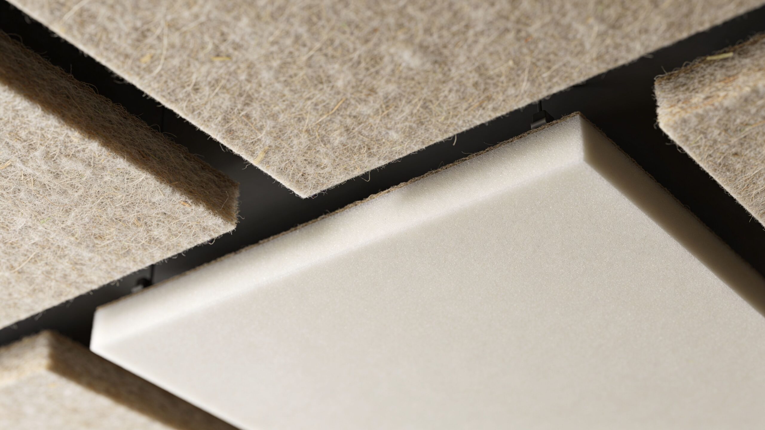 Close-up of modern acoustic ceiling sound baffles with textured fiber material and a smooth white panel.