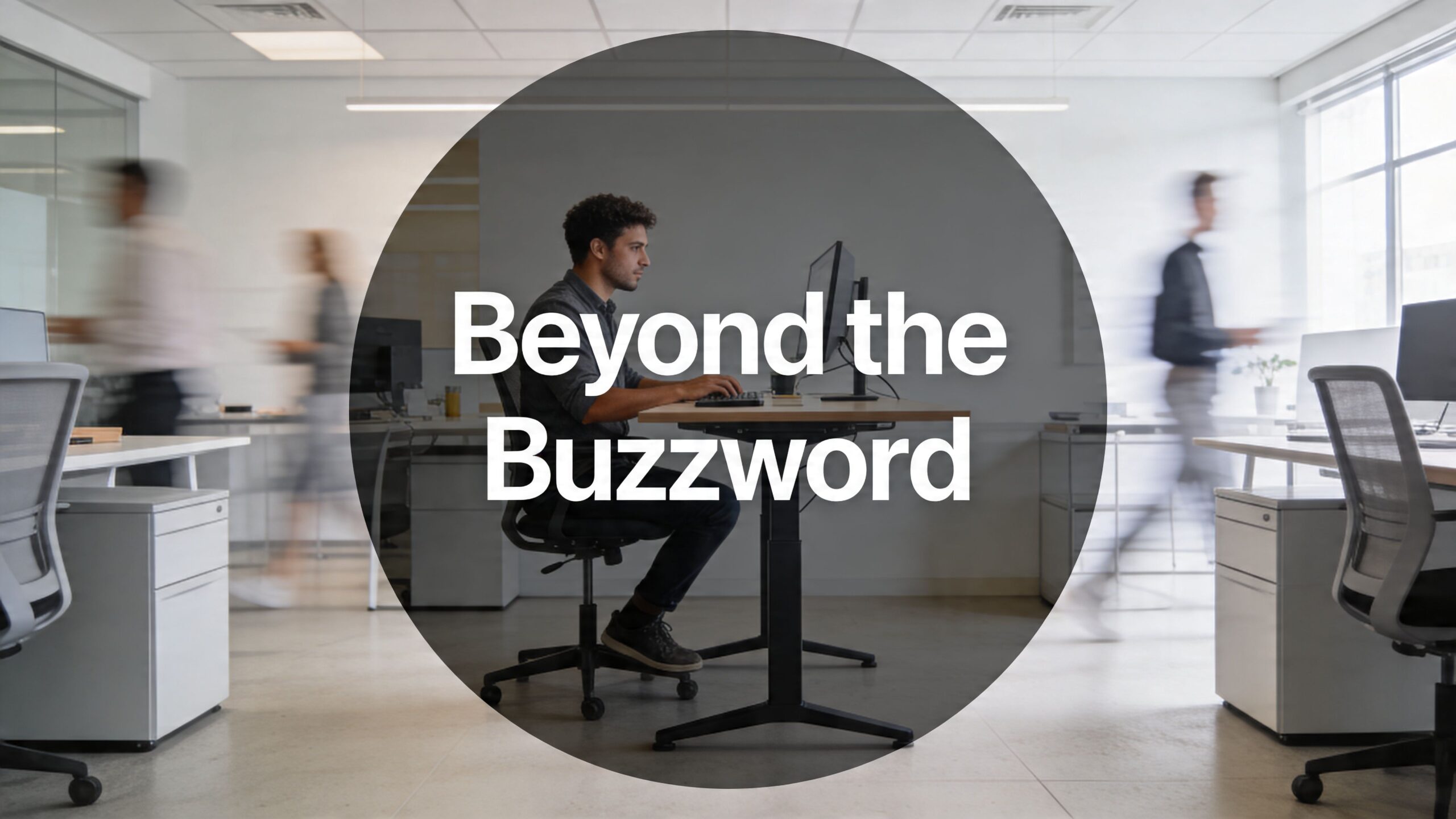 A man working on a computer at a desk with adjustable legs in a busy office.